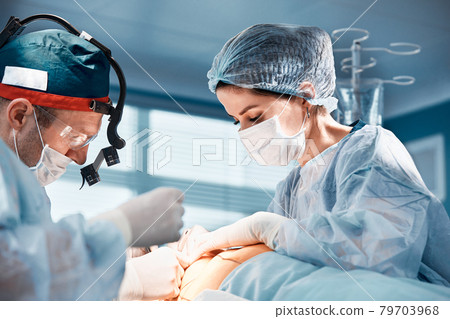 Close-up of surgeons in the operating room during the operation.Modern medicine, Medical workers during the Covid19 coronavirus pandemic fight and save lives. 79703968