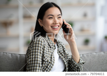 Pretty woman chilling on couch at home, talking on phone Pretty woman chilling on couch at home, talking on phone 79704811