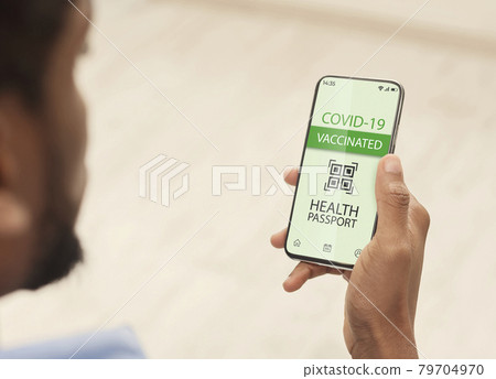 Black man using smartphone with digital health passport for covid-19 Black man using smartphone with digital health passport for covid-19 79704970
