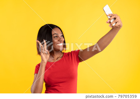 African American Lady Making Selfie Gesturing Victory Sign, Yellow Background African American Lady Making Selfie Gesturing Victory Sign, Yellow Background 79705359