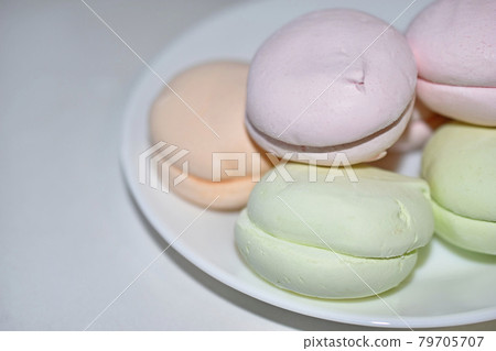 Colorful delicious marshmallows on a white plate Colorful delicious marshmallows on a white plate 79705707