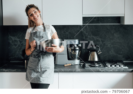 beautiful woman housewife cooks delicious food in the kitchen beautiful woman housewife cooks delicious food in the kitchen 79706067