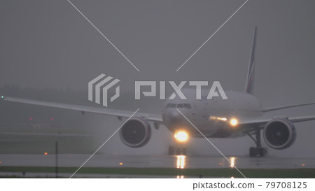 Airplane of Aeroflot taxiing on wet tarmac in the rain Airplane of Aeroflot taxiing on wet tarmac in the rain 79708125