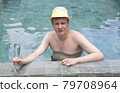happy young man in hat at pool with cocktail 79708964