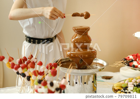 Fondue with a chocolate fountain and sweets for it.Sweet theme Fondue with a chocolate fountain and sweets for it.Sweet theme 79709811