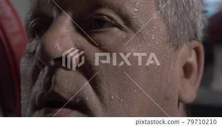 Man wiping sweaty face with towel 79710210