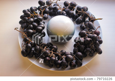 White and blue ball stands in the middle of a plate, and around 79710226