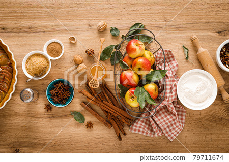 Ingredients for cooking Thanksgiving autumn apple pie with fresh fruits, cinnamon and walnuts on wooden table, top view 79711674