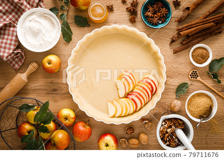 Cooking Thanksgiving autumn apple pie with fresh fruits and walnuts on wooden table, top view 79711676