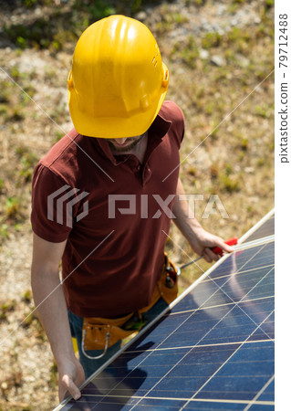 Technician Adjusting Solar Panels 79712488