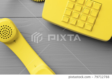 Yellow .landline phone on gray background top view 79712788