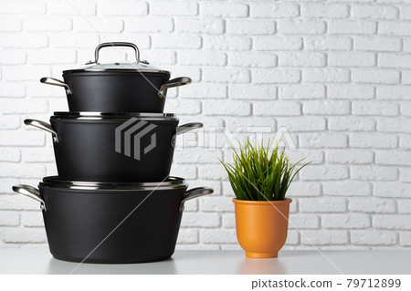 Black kitchenware on table against white brick wall Black kitchenware on table against white brick wall 79712899