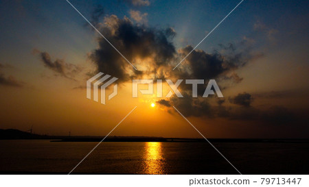 Sunset stripes and black clouds reflected on the sea surface 79713447