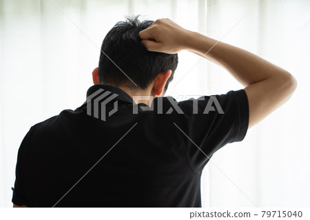 Back view of a man hitting the back of his head with his fist 79715040