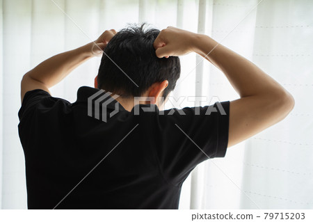 一名男子雙手抱頭站在窗邊的後方視圖 一名男子雙手抱頭站在窗邊的後方視圖 79715203