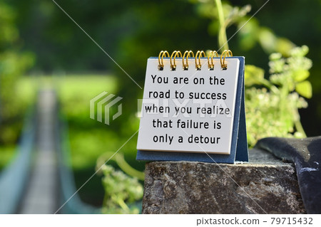 Motivational quote on white note with blurred background of hanging bridge 79715432