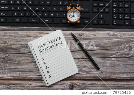 Text a notepad with alarm clock on a black keyboard Text a notepad with alarm clock on a black keyboard 79715436