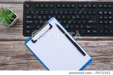 Home office workspace with keyboard, clipboard, pen and potted plant. Flat lay, top view Home office workspace with keyboard, clipboard, pen and potted plant. Flat lay, top view 79715501