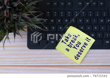 Text on yellow note with keyboard and potted plant on wooden table Text on yellow note with keyboard and potted plant on wooden table 79715542