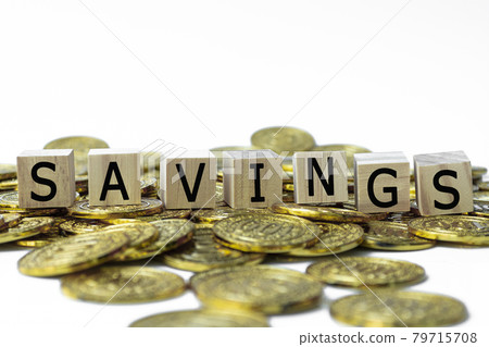 Savings text on wood block with a pile of coins 79715708