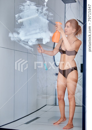 Slender Caucasian woman in underwear tidies up shower. 79715847