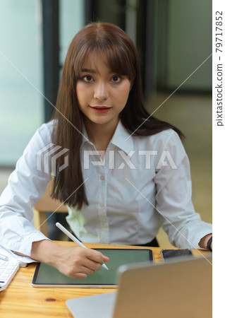 Gorgeous businesswoman working at office with tablet 79717852