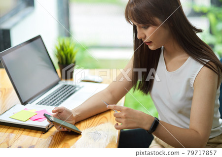 Female freelancer pay monthly expenses via online payment application on smartphone Female freelancer pay monthly expenses via online payment application on smartphone 79717857