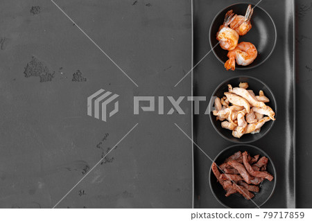 Three bowls with cooked beef, chicken slices and prawns on black background Three bowls with cooked beef, chicken slices and prawns on black background 79717859