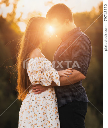 Portrait of young romantic couple kissing in the sun 79718350