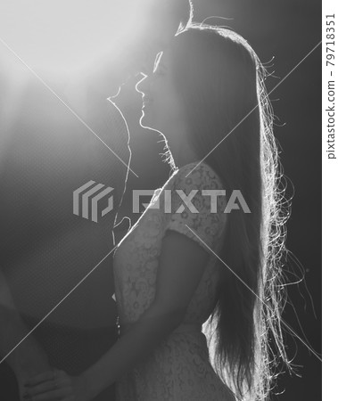 Portrait of young romantic couple kissing in the sun 79718351