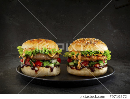 Two Fresh tasty burgers on dark background Two Fresh tasty burgers on dark background 79719272