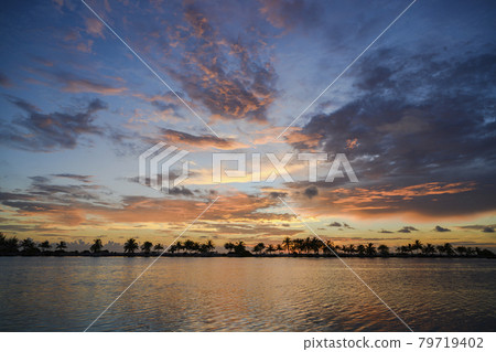 Colorful sunset with silhouettes of palm trees on a tropical island in the Maldives 79719402