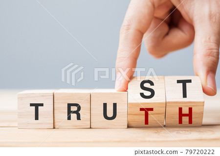 Business man hand change wooden cube block with TRUST and TRUTH business word on table background. Trustworthy, faith, beliefs and honesty concept 79720222