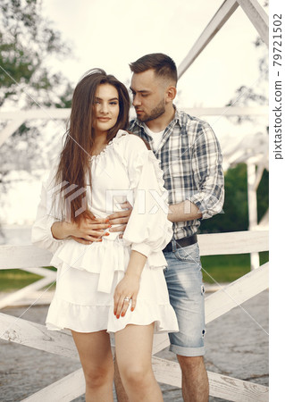 Beautiful couple spend time in a summer park Beautiful couple spend time in a summer park 79721502