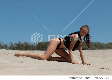 Graceful woman in bikini on sandy beach 79722077