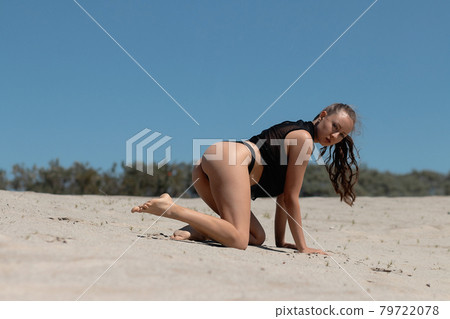 Graceful woman in bikini on sandy beach Graceful woman in bikini on sandy beach 79722078