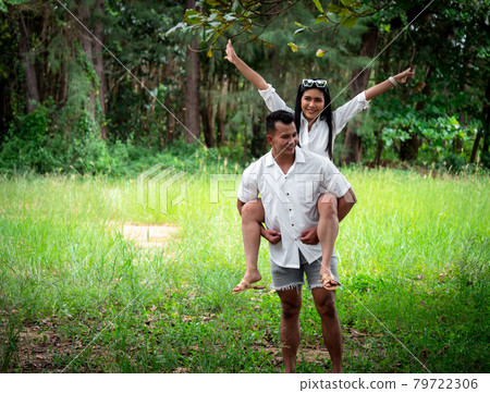 Handsome man giving piggyback ride to his pretty girlfriend are relaxing and traveling to natural attractions and the national park.	 79722306