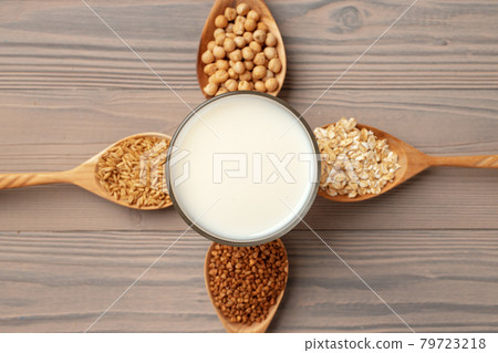 Top view of vegan milk and grains in wooden spoons on wooden surface Top view of vegan milk and grains in wooden spoons on wooden surface 79723218