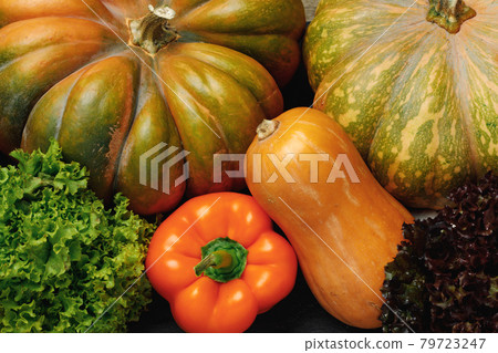 Close up of pumpkins and bell peppers in pile 79723247