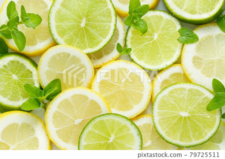 Slices of lime and lemon decorated with herbs. A background of many 79725511