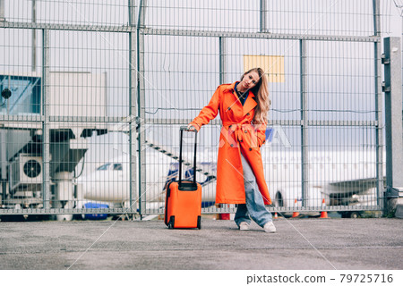 happy woman walking near airport, with luggage. Air travel, summer holiday happy woman walking near airport, with luggage. Air travel, summer holiday 79725716