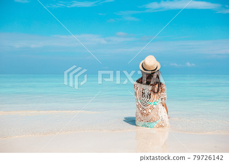 Woman laying on the beach enjoying summer holidays looking at the sea 79726142