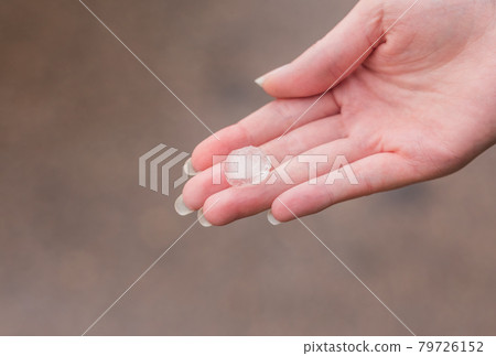 Hailstone on a hand of women after strong storm Hailstone on a hand of women after strong storm 79726152