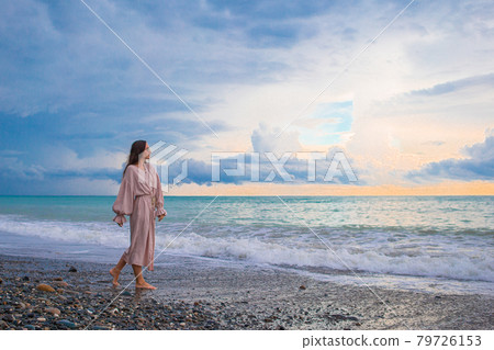 Woman laying on the beach enjoying summer holidays looking at the sea Woman laying on the beach enjoying summer holidays looking at the sea 79726153