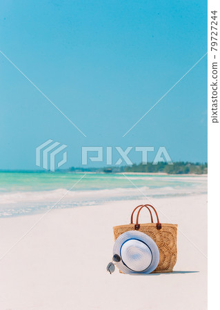 Beach accessories - straw bag, hat and unglasses on the beach 79727244