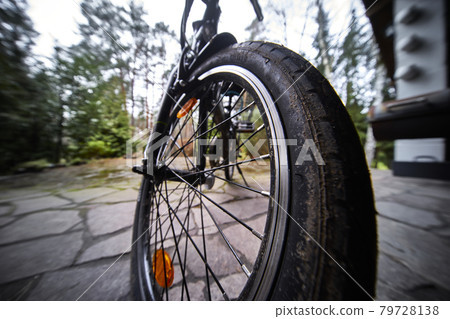 Close-up of the front tire of a bicycle, wide angle with selective focus 79728138