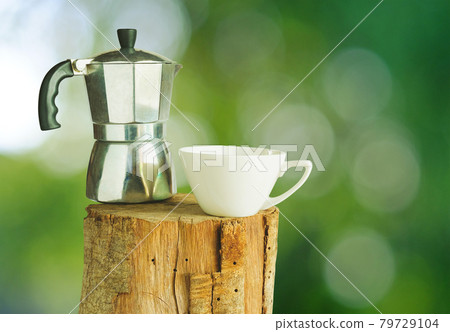 Ceramic coffee mug on stump with nature background. 79729104