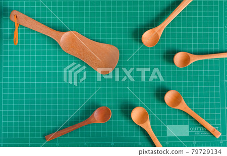 Kitchenware and wood spoon on cutting mat background. 79729134