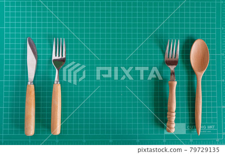 Kitchenware and wood spoon on cutting mat background. 79729135