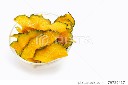 Green pumpkin slice chips in glass bowl on white background. 79729417